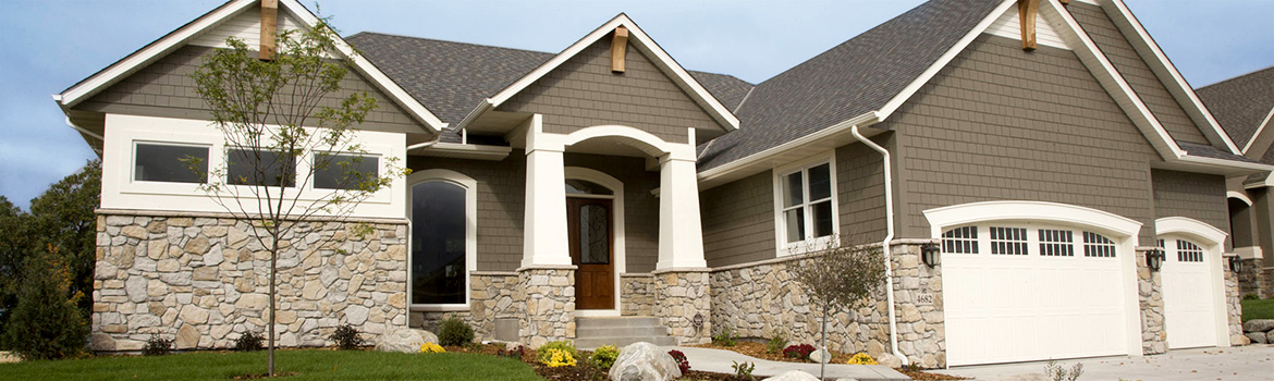Front of home with an assortment of stone siding and colors of gray, tan and brown